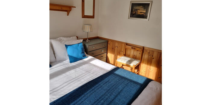 River Edge Lodge double room 2 river edge lodge double room with white bed linen and teal throw with sun slanting in through the window
