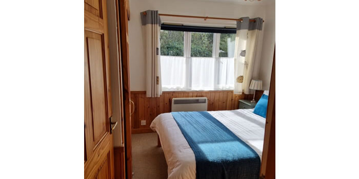 River Edge Lodge double room 3 double bedroom of River Edge Lodge looking out the window to the trees and shrubs