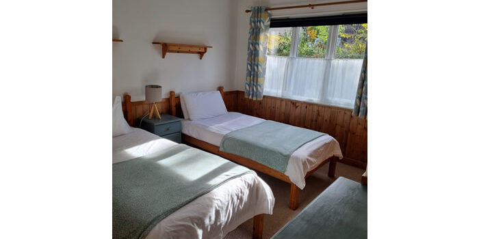 River Edge Lodge twin room 2 twin room of River Edge Lodges, looking out the window to the trees and shrubs
