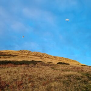 two hang gliders above Bishop Hill, Fife in a blue sky