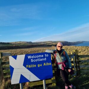 Welcome to Scotland sign with mary beside it.